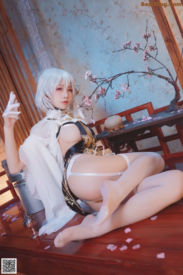 A woman in a white dress sitting on a wooden table.